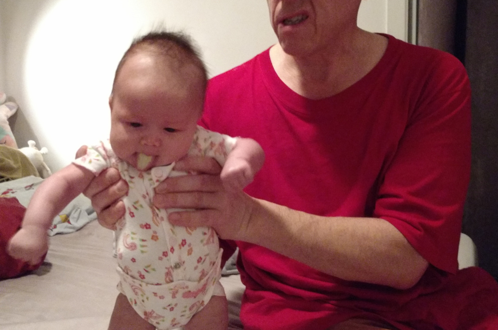 Photo of Papa Zesser holding baby Baobao as she shows her milk tongue.