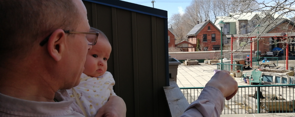 Photo of Papa Zesser pointing out the dangers in an empty playground to his thoroughly disinterested daughter.