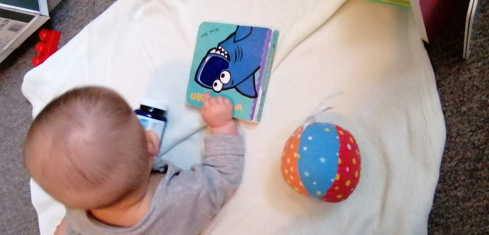 Photo of Baobao with hand upon the book which earlier had trapped her other hand.