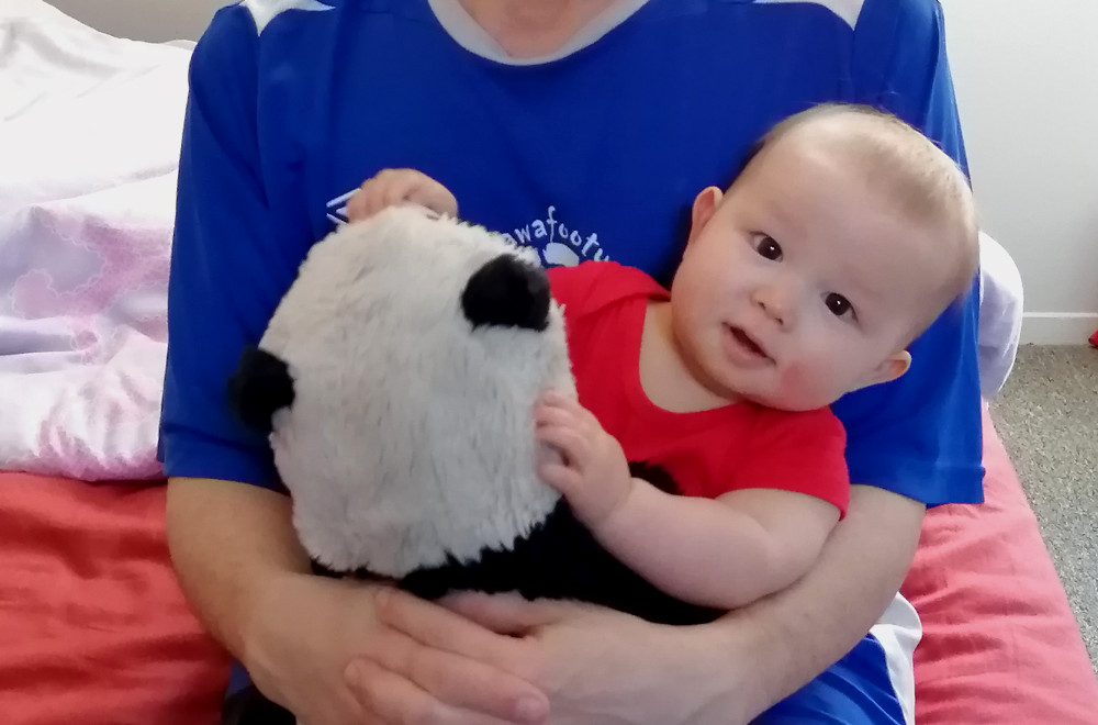 Detail of photo of Papa Zesser holding Carl the Second and Baobao.