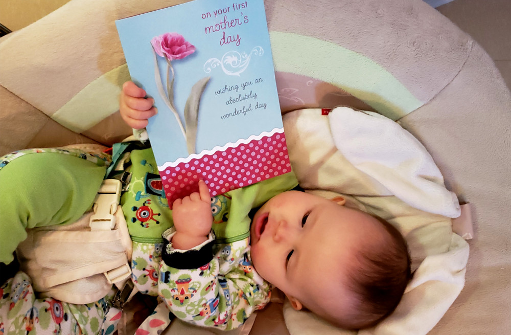 Photo of baby Baobao holding Mother's Day card.