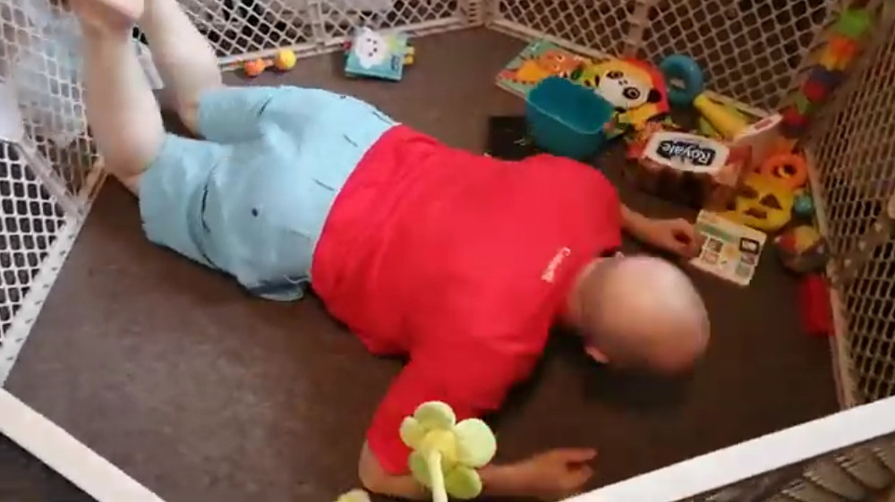 Photo of Papa Zesser face down in his Baobao's play-pen