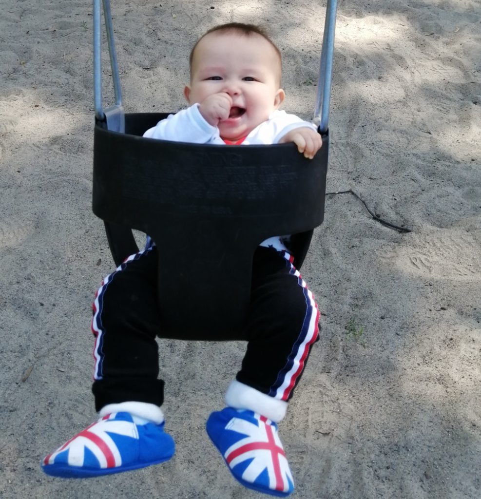 Detail of photo of baby Baobao on a swing for the very first time.