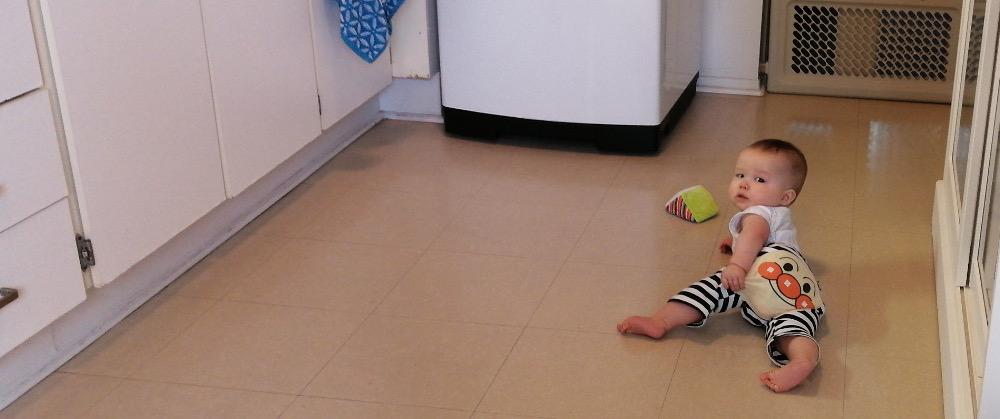 Photo of Baby Baobao crawling on the kitchen floor.