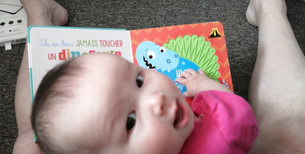 Photo of baby Baobao looking away from book into camera.