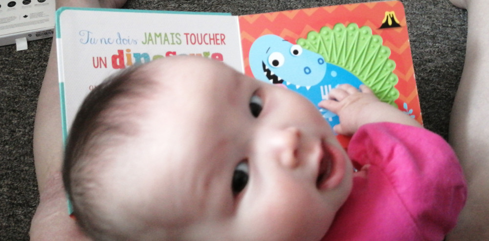 Photo of baby Baobao with the book, Ne touche jamais un dinosaure!