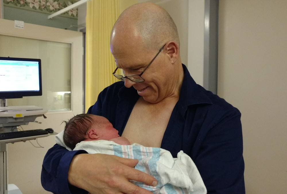 Photo of Papa Zesser holding baby Baobao several hours after her birth, August 19, 2019.