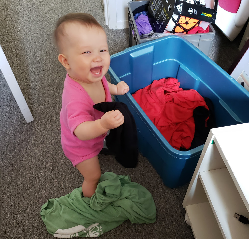 Detail of photo of baby Baobao, August 23, 2020, triumphantly playing with Papa Zesser's dirty laundry.