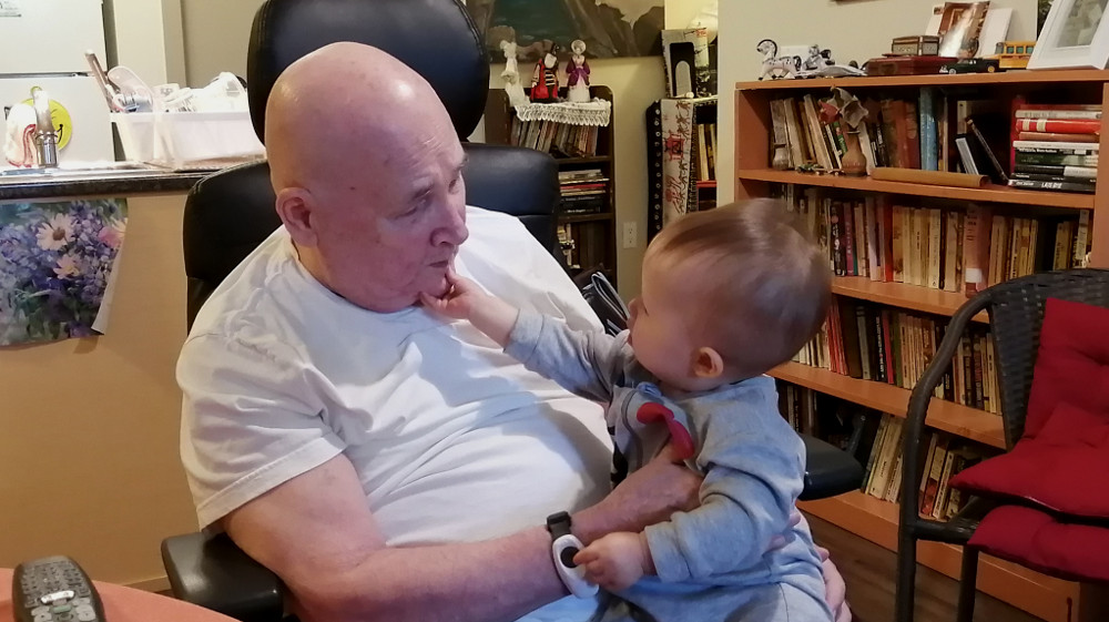 Detail of photo of baby Baobao grabbing her grampa Carl's chin with her claws.