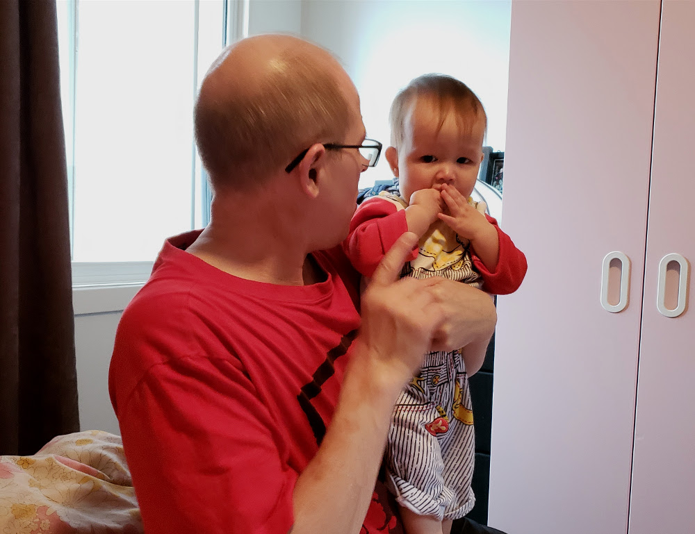 Photo of Papa Zesser holding toddler Baobao while explaining something to her. Photo by Mama Raven, November 11, 2020.