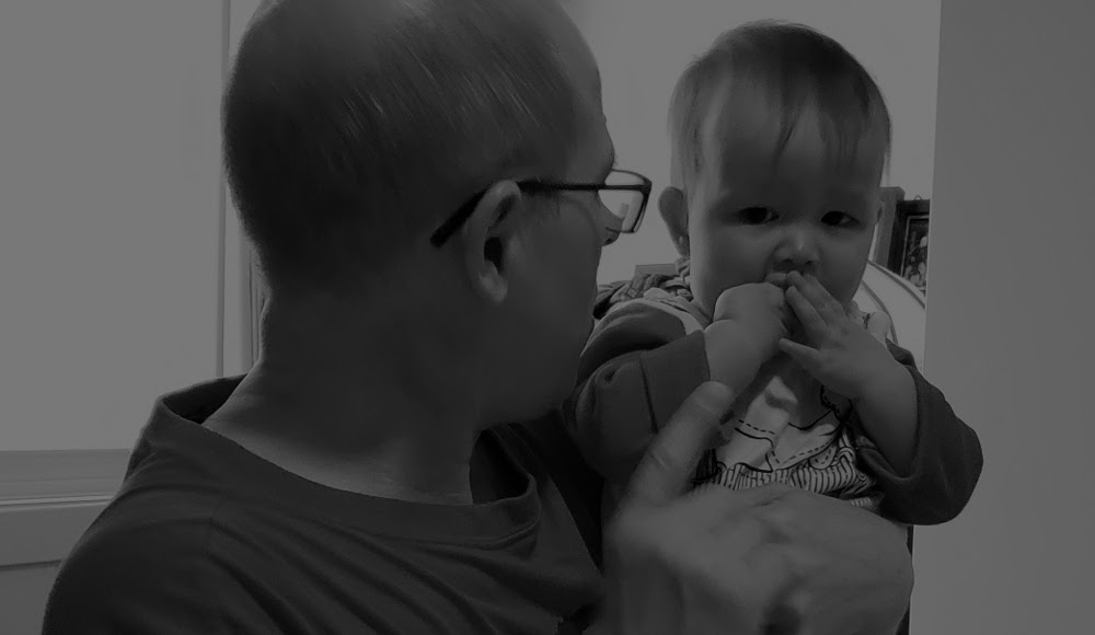 Black and white photo of Papa Zesser wagging his finger at toddler Baobao. Photo by Mama Raven, November 11, 2020.